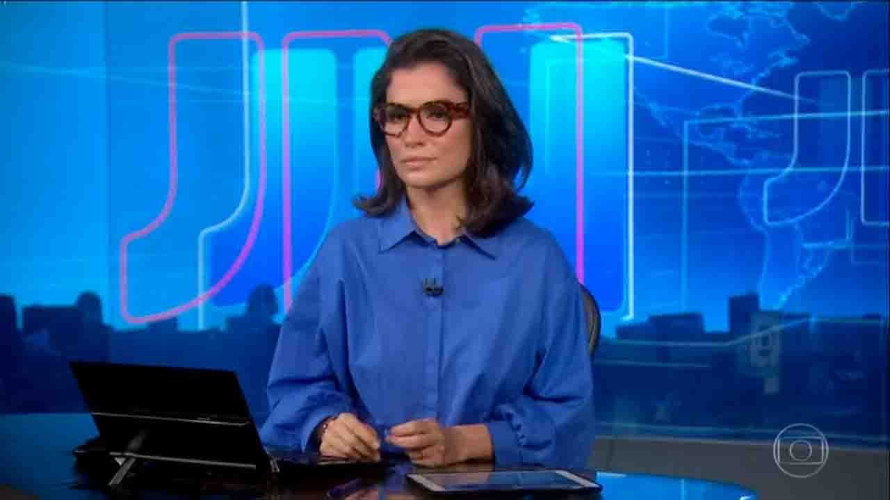 Renata Vasconcellos sentada na bancada do Jornal Nacional