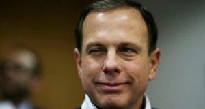 João Doria olhando meio de lado e com uma piscadela e leve sorriso