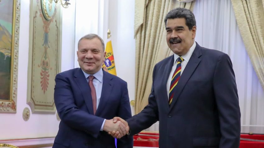 O vice-primeiro ministro da Rússia, Yuri Borisov, e o presidente da Venezuela, Nicolás Maduro Moros, dando um aperto de mão e sorrindo para a foto.