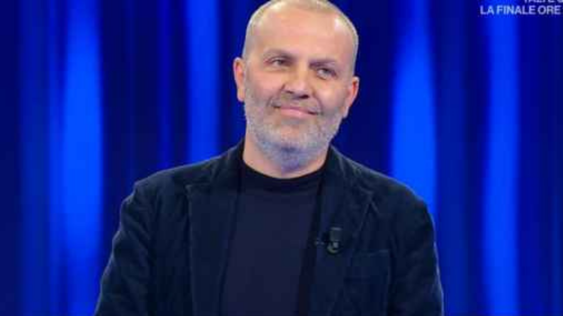O médico que liderou movimento antivacina, Pasquale Bacco está em um estúdio de TV, com roupas pretas e olhar sério. Ele usa barba branca e cabelo calvo.