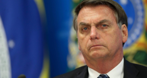 Deputado pede investigação de Bolsonaro por campanha antecipada. Ele tem olhar sério e de roupa, com aparência de estar pensativo.