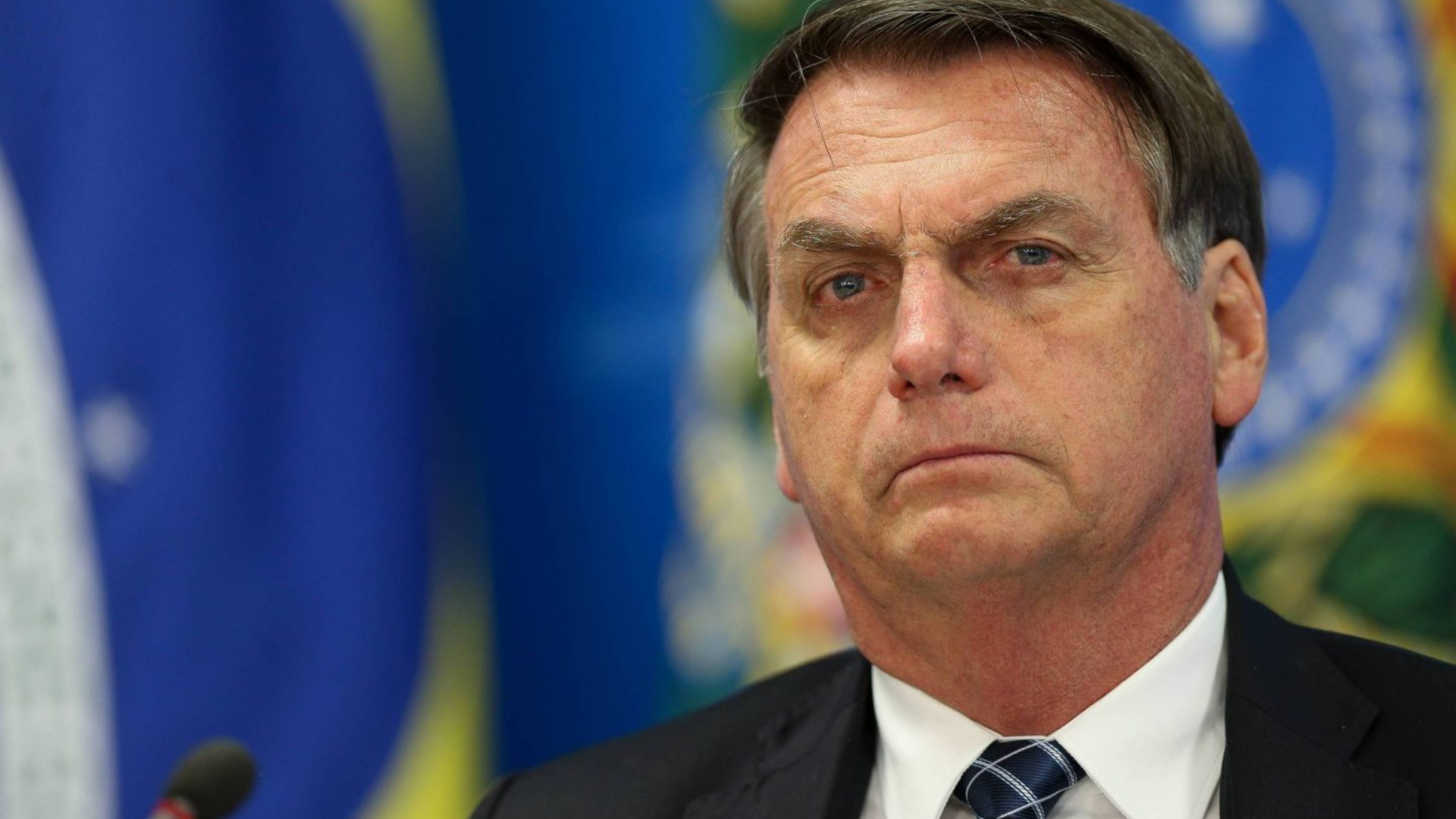 Deputado pede investigação de Bolsonaro por campanha antecipada. Ele tem olhar sério e de roupa, com aparência de estar pensativo.