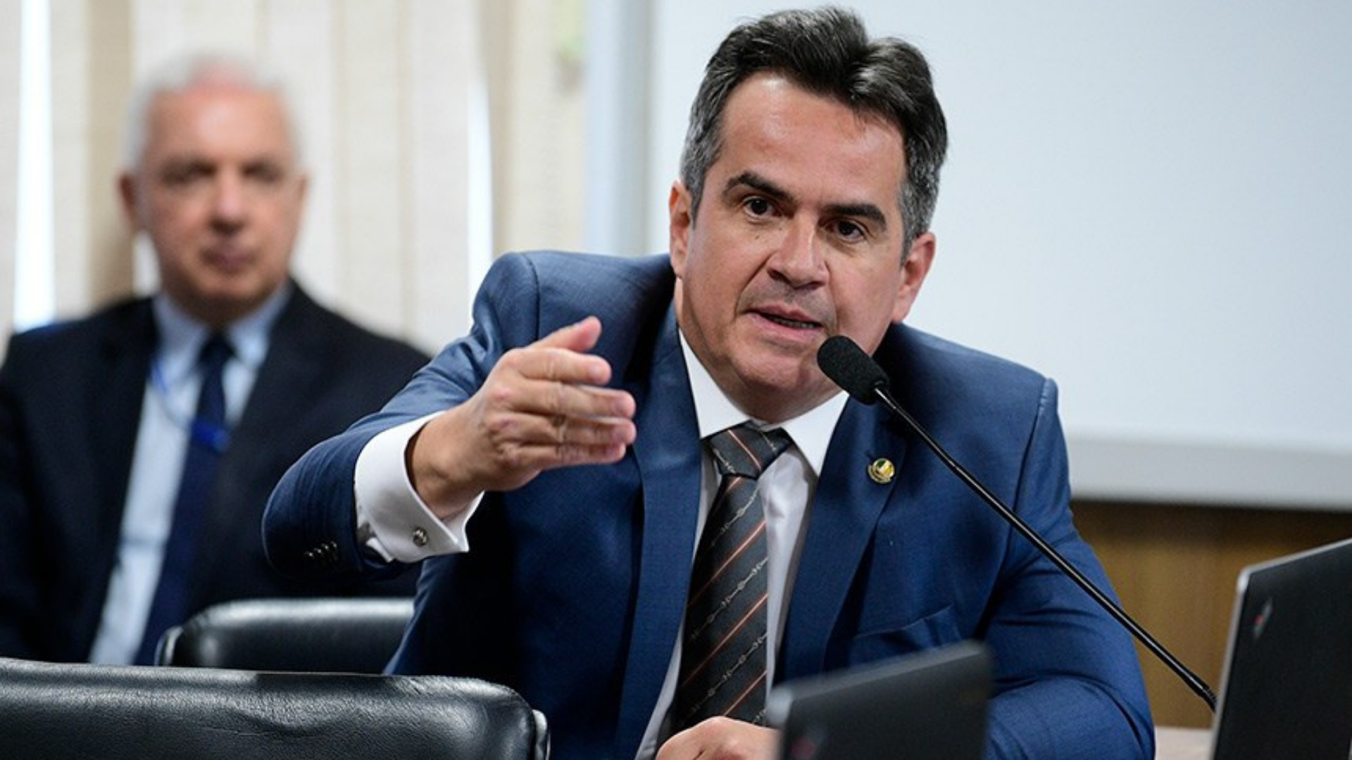 Bolsonaro transforma Ciro Nogueira chefe de outros ministros. Ciro Nogueira usa terno azul, está no plenário da câmaro falando para os demais deputados.