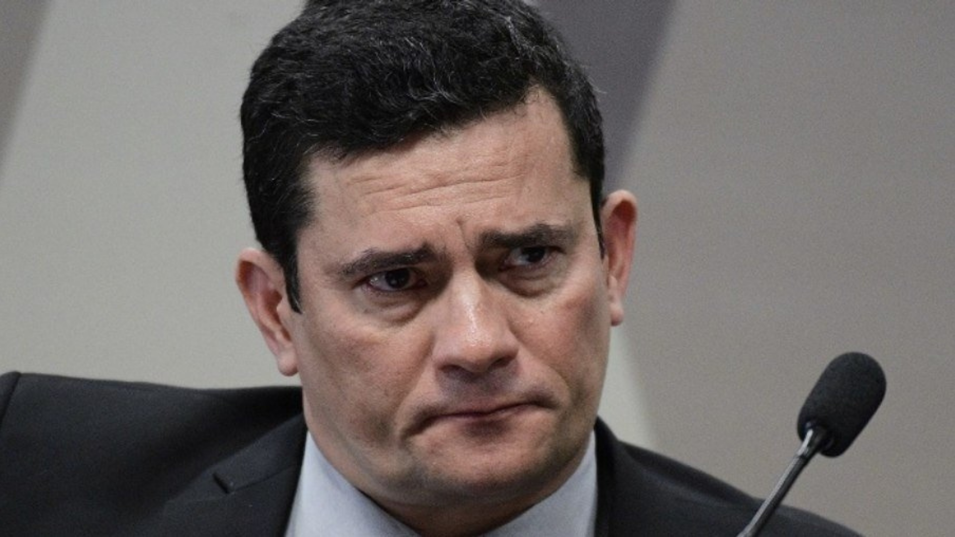 Moro mentiu? O ex-juiz tem uma expressão de preocupação. Usa terno preto e cabelo preto.