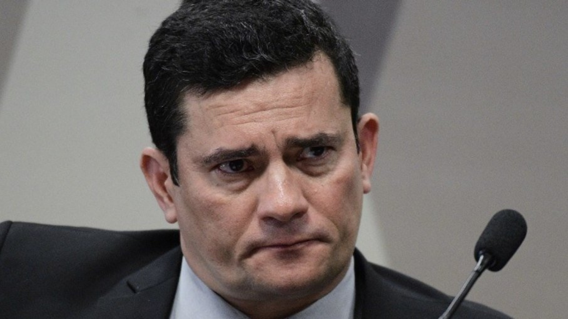 Moro mentiu? O ex-juiz tem uma expressão de preocupação. Usa terno preto e cabelo preto. 