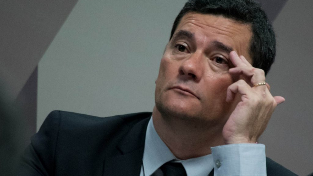 Foto de Sergio Moro com terno preto, mão esquerda na sombrancelha e olhar de preocupação