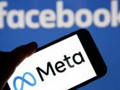 Foto de celular com a logo da Meta, ao fundo há o nome 'Facebook" em branco com painel azul