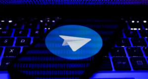 Acordo sobre Telegram na Câmara ainda tem pontas soltas. Foto do ícone do aplicativo em um celular, é um avião de papel branco dentro de um círculo azul.