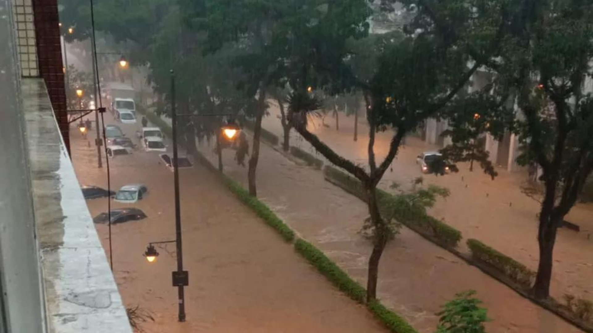 Chuva em Petrópolis causa destruição. Na imagem, uma avernina alagada com vários caros submersos.