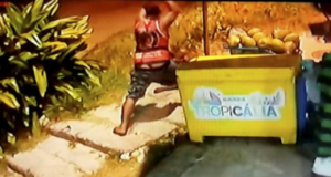 Foto de homem agredindo Moise ao lado de um freezer com o nome "Quiosque Tropicália"