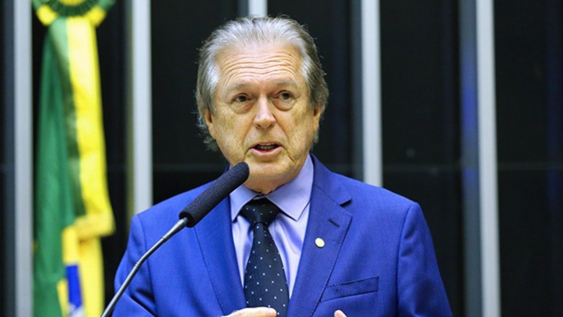 PSDB, MDB e União Brasil abrem negociação. Foto de Luciano Bivar com terno azul, falando no plenário da Câmara. Ele tem cabelos brancos e pele branca.