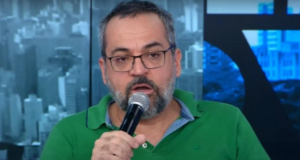Weintraub faz enquete provocando Bolsonaro. Ele usa camisa verde e fala ao micrfone na foto.