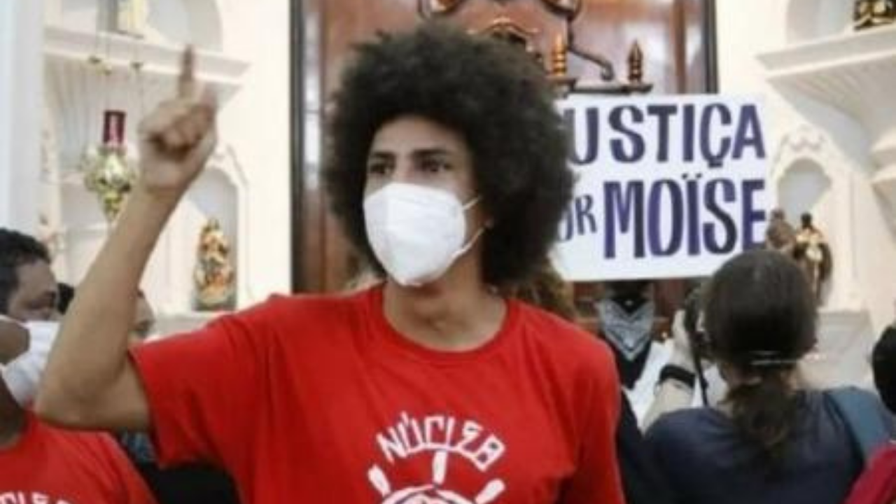 Vereador nega invasão à igreja. Ele usa máscara, cabelo black e protesta contra morte de pessoas negras em igreja.