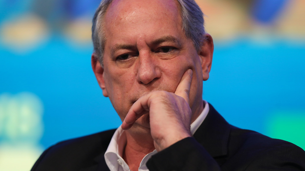 Foto de ciro Gomes com terno preto e olhar preocupado. Ele coloca a mão esquerda na bochecha