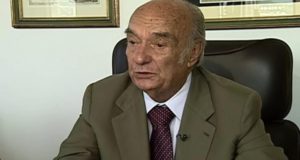 Candido mMendes morre aos 93 anos. Ele usa um terno marmmarro, é calvo e tem ple branca