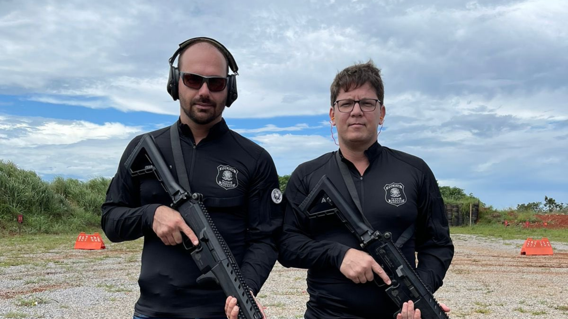 Eduardo Bolsonaro posta foto armado com Mario Frias. Eles usam roupas pretas enquanto seguram fuzis.