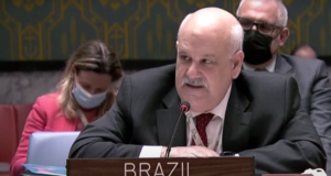 Ronaldo Costa Filho, embaixador brasileiro na ONU, falando na reunião do conselho de segurança da organização. Ele está sentado, com o microfone a sua frente e uma placa de madeira escrito "Brazil".