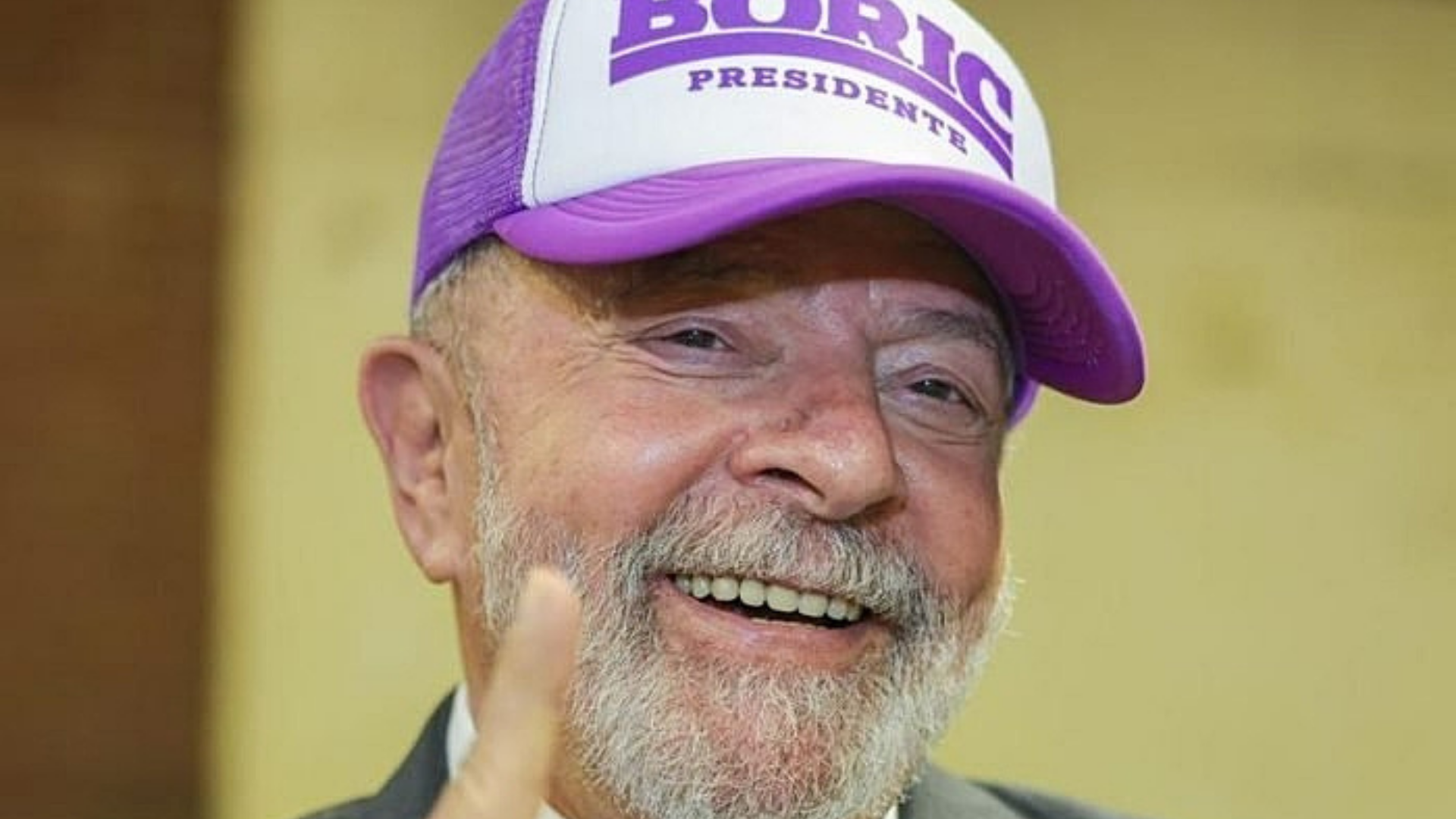 Lula avisa que não irá ao Chile para posse de Boric. O ex-presidente está sorrindo, com um terno preto, e usa um boné com o nome Boric".