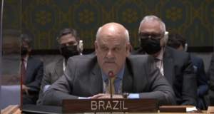 Mesmo pressionado, governo brasileiro mantém neutralidade na ONU. Costa Gilho aparece em um evento, ele usa um terno preto, é calvo e tem bigode branco.