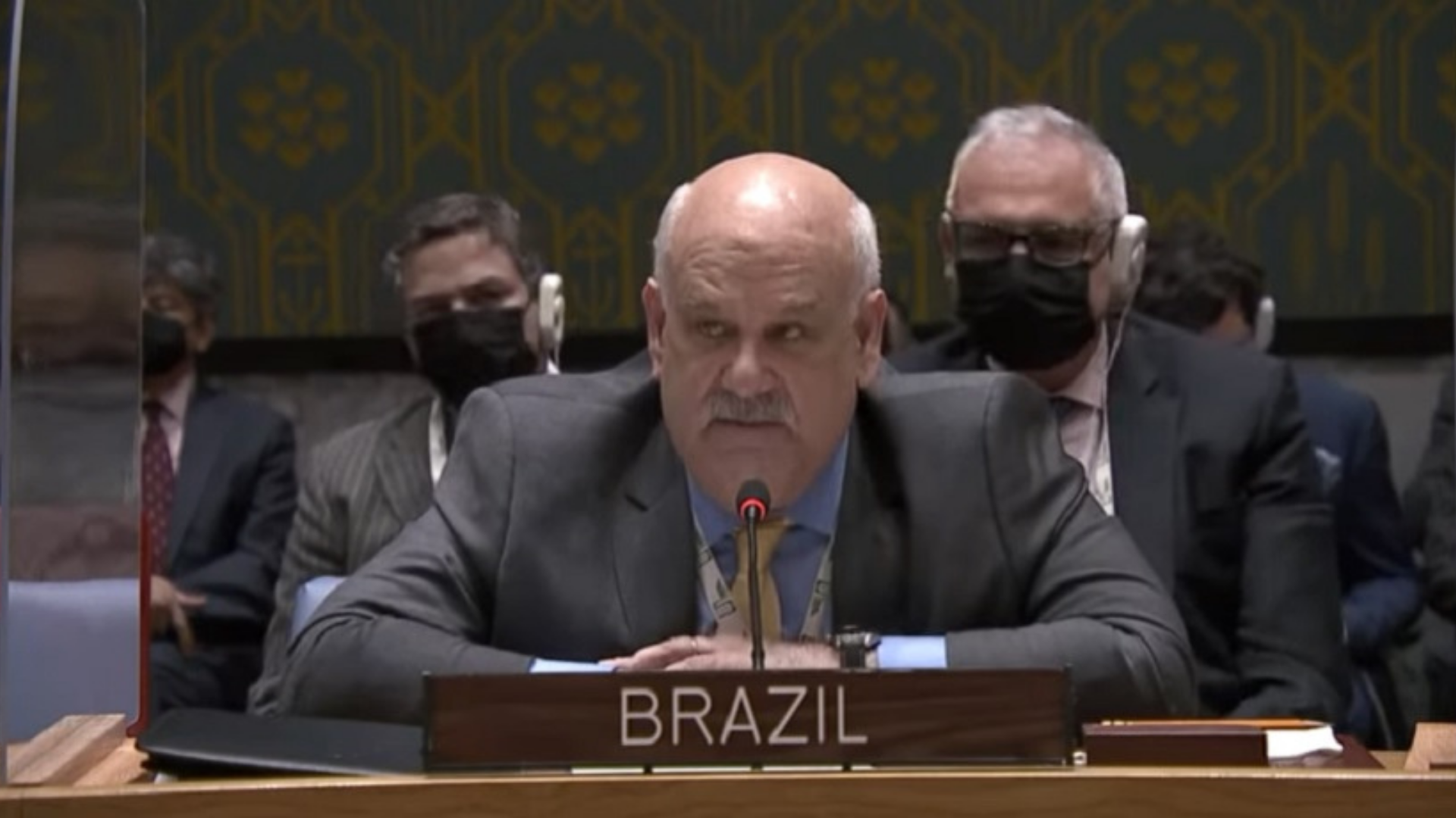Mesmo pressionado, governo brasileiro mantém neutralidade na ONU. Costa Gilho aparece em um evento, ele usa um terno preto, é calvo e tem bigode branco.