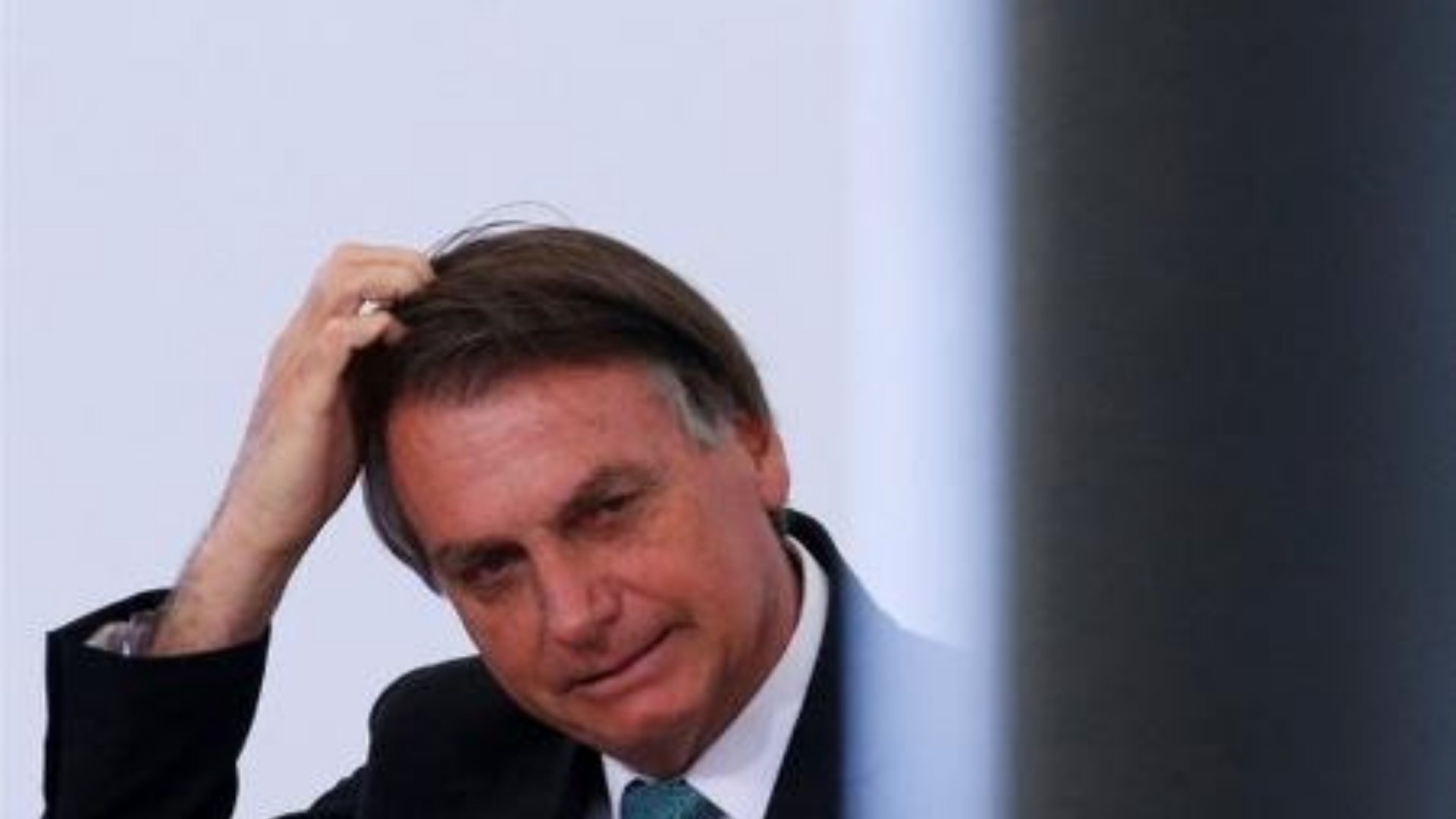 Bolsonaro não para de humilhar o país. Bolsonaro tem olhar preocupado e mão na cabeça.