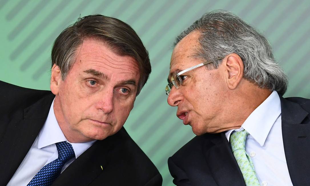Paulo Guedes cochichando para Bolsonaro