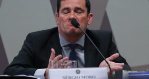 Moro fazendo careta com um microfone diante dele