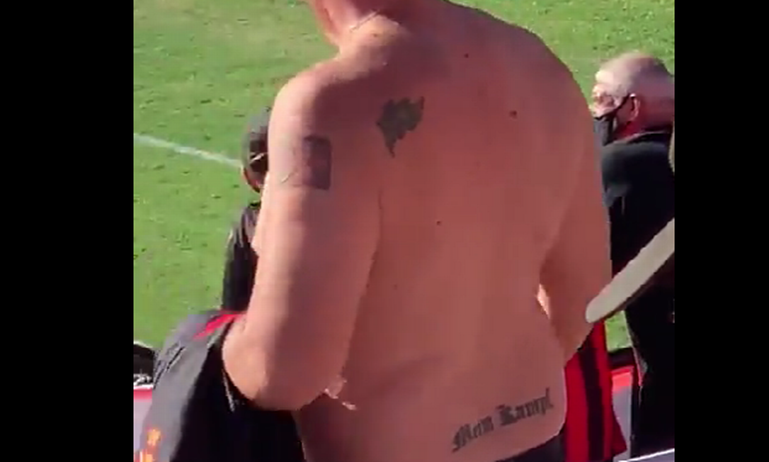 Homem sem camisa, com tatuagem nas costas escrito: "Mein Kampf", título de livro de Hitler.