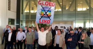 Bolsonaro muda valores repassados à emissores. Na foto, Bolsonaro segura uma placa escrita Globolixo ao lado de aliados
