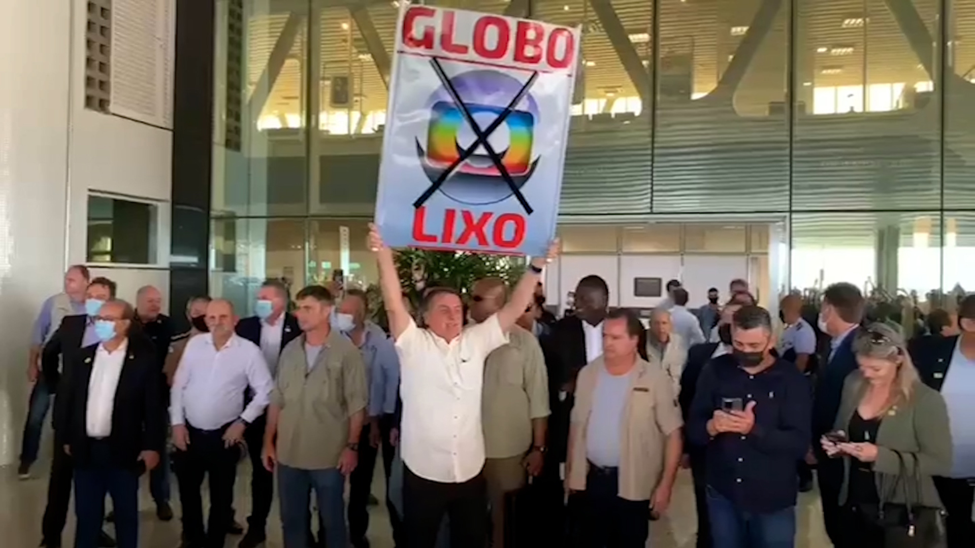 Bolsonaro muda valores repassados à emissoras. Na foto, Bolsonaro segura uma placa escrita Globolixo ao lado de aliados