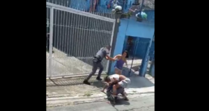 Trecho da abordagem da polícia, em que o homem está em luta corporal com um dos policiais. Outro PM chega para dar reforço. Uma mulher que manda os policias pararem com a violência também aparece na imagem.