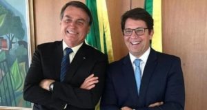 Jair Bolsonaro e Mario Frias, em pé, um ao lado do outro, rindo