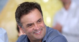 A imagem de Aécio Neves sorrindo e olhando para o lado.