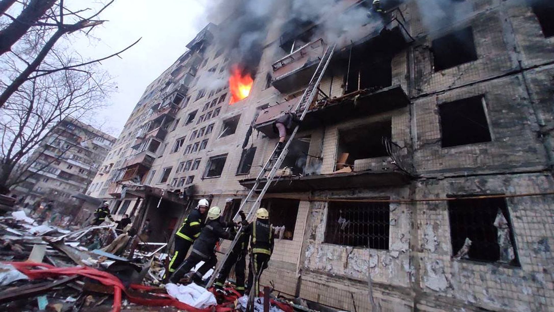 Bombeiros combatem incêndio em um prédio atingido por bombardeio aéreo russo, no bairro de Obolon, em Kiev