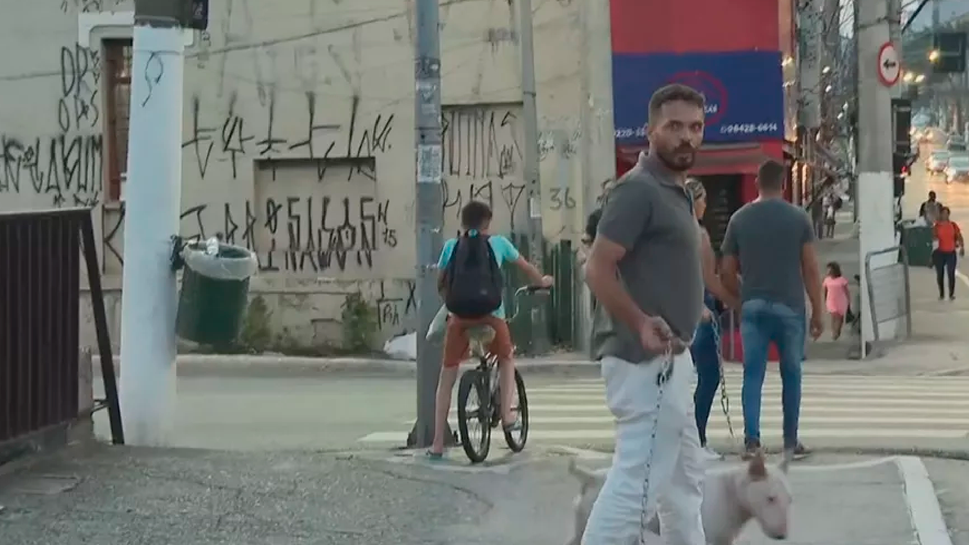 Homem acusado der ser o responsável pelas agressões segura um cachorro e a corrente que usou no ataque aos repórteres da Globo