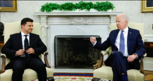 Volodymyr Zelensky e Joe Biden sentados conversando na Casa Branca.
