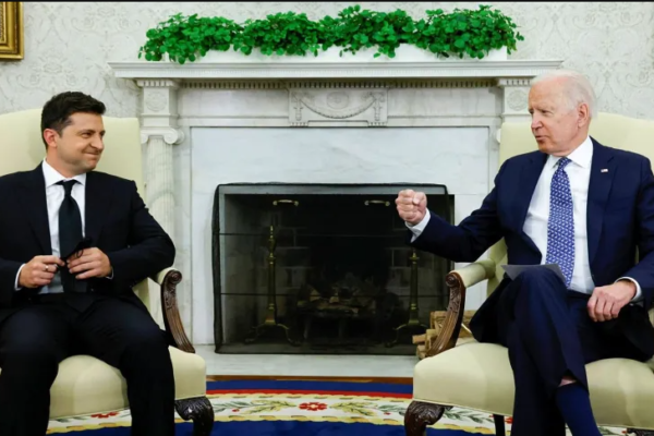 Volodymyr Zelensky e Joe Biden sentados conversando na Casa Branca.