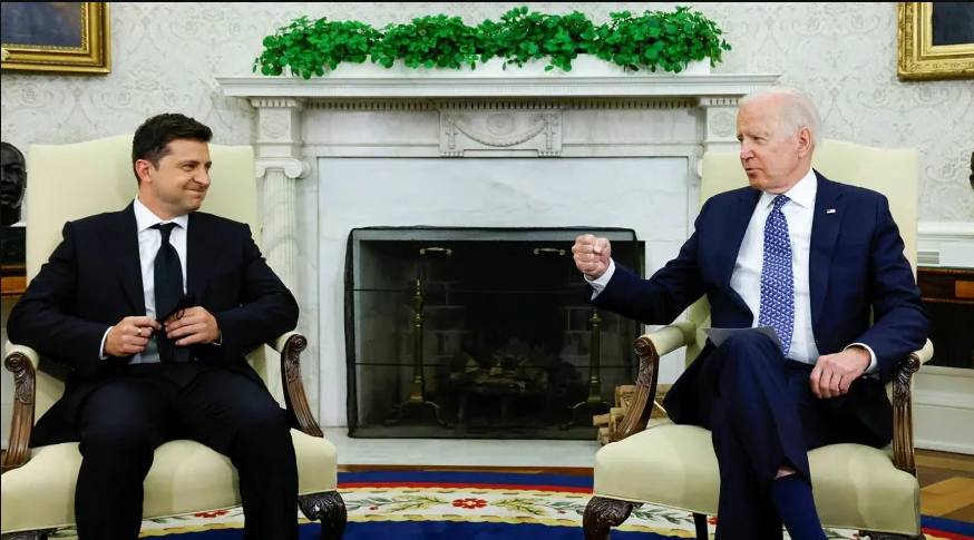 Volodymyr Zelensky e Joe Biden sentados conversando na Casa Branca.; eles são acusados de terem armas biológicas na Ucrânia