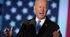 Joe Biden discursando, com as mãos abertas