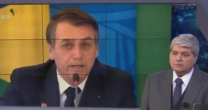 O apresentador Datena assistindo a um pronunciamento de Bolsonaro durante seu programa Brasil Urgente, na Band.