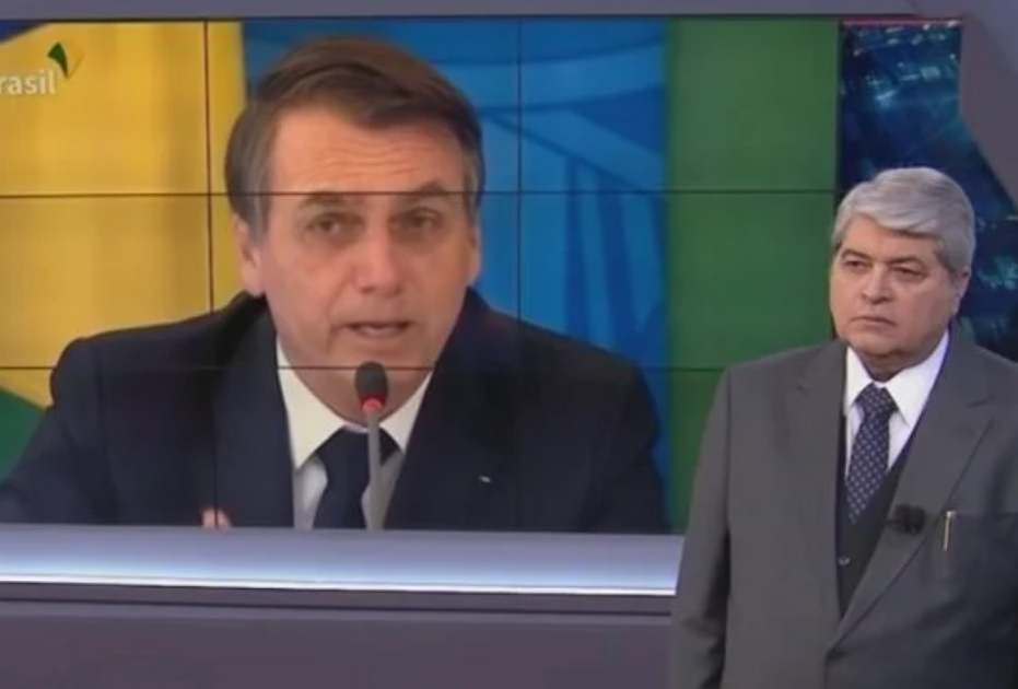 O apresentador Datena assistindo a um pronunciamento de Bolsonaro durante seu programa Brasil Urgente, na Band.