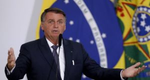 Bolsonaro discursando com os braços abertos.