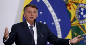 Bolsonaro discursando com os braços abertos.