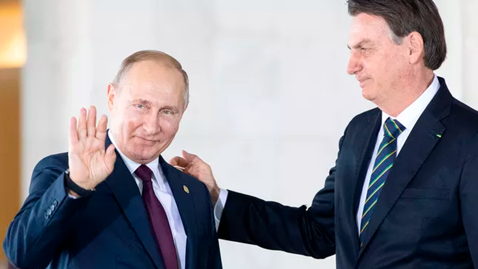 Presidente Russo, Vladimir Putin ascena em direção as câmeras e Bolsonaro toca em seu ombro