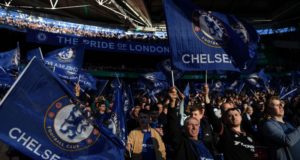 Torcedores do Chelsea no estádio, com camisas e bandeiras.