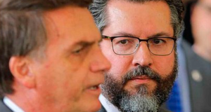 ex-chanceler Ernesto Araújo observa o presidente Jair Bolsonaro (PL) que está de perfil