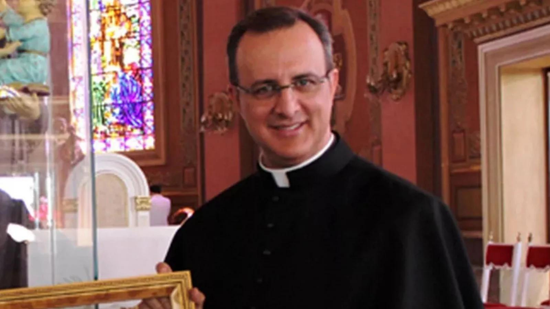 Papa Francisco expulsa padre acusado de abusos sexuais em SP. Padre sorri em foto usando roupa preta, sorrindo e com óculos de grau.