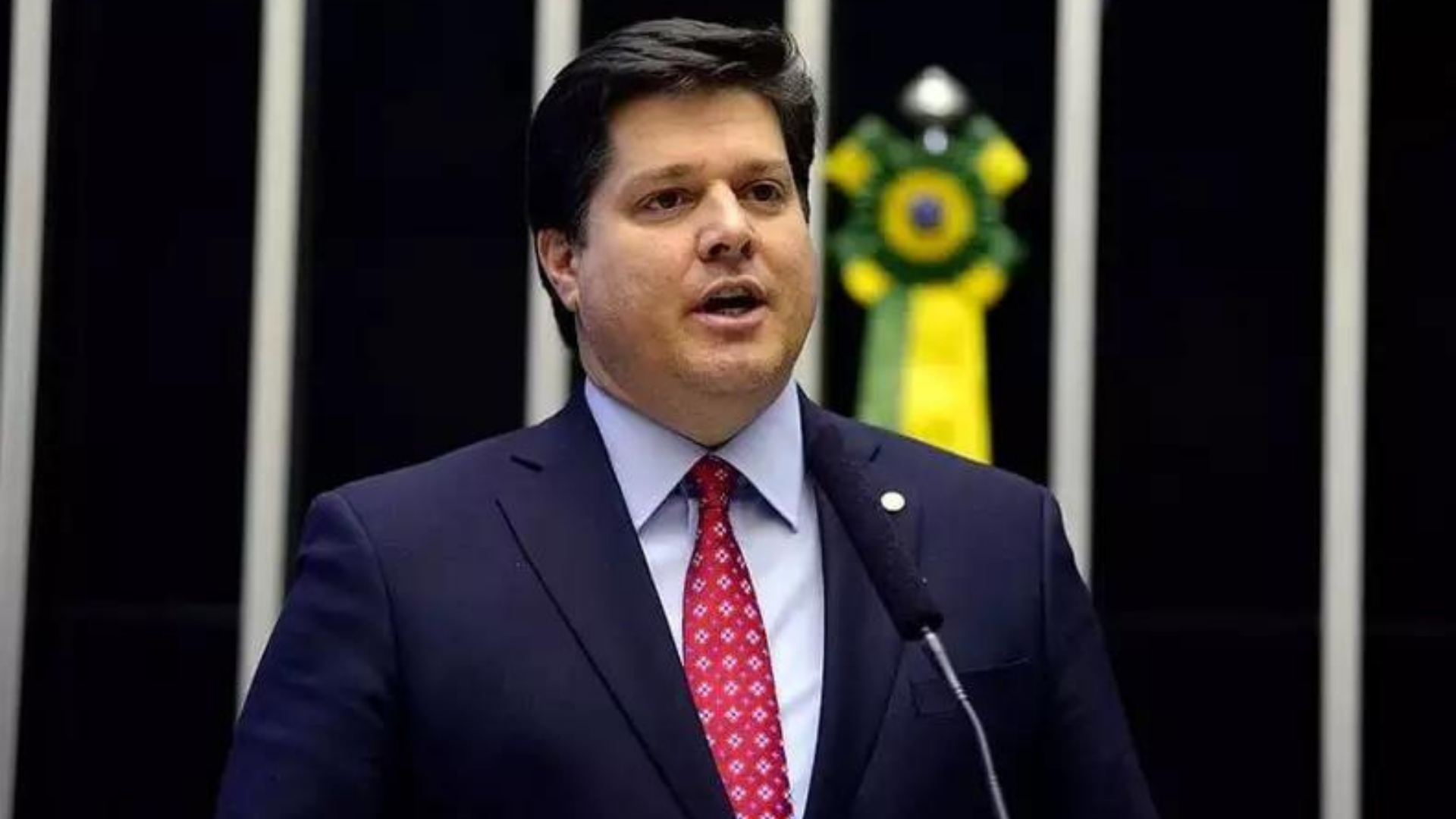 MDB bate martelo sofre federação partidária. Baleia Rossi discursa na Câmara com terno azul marinho.