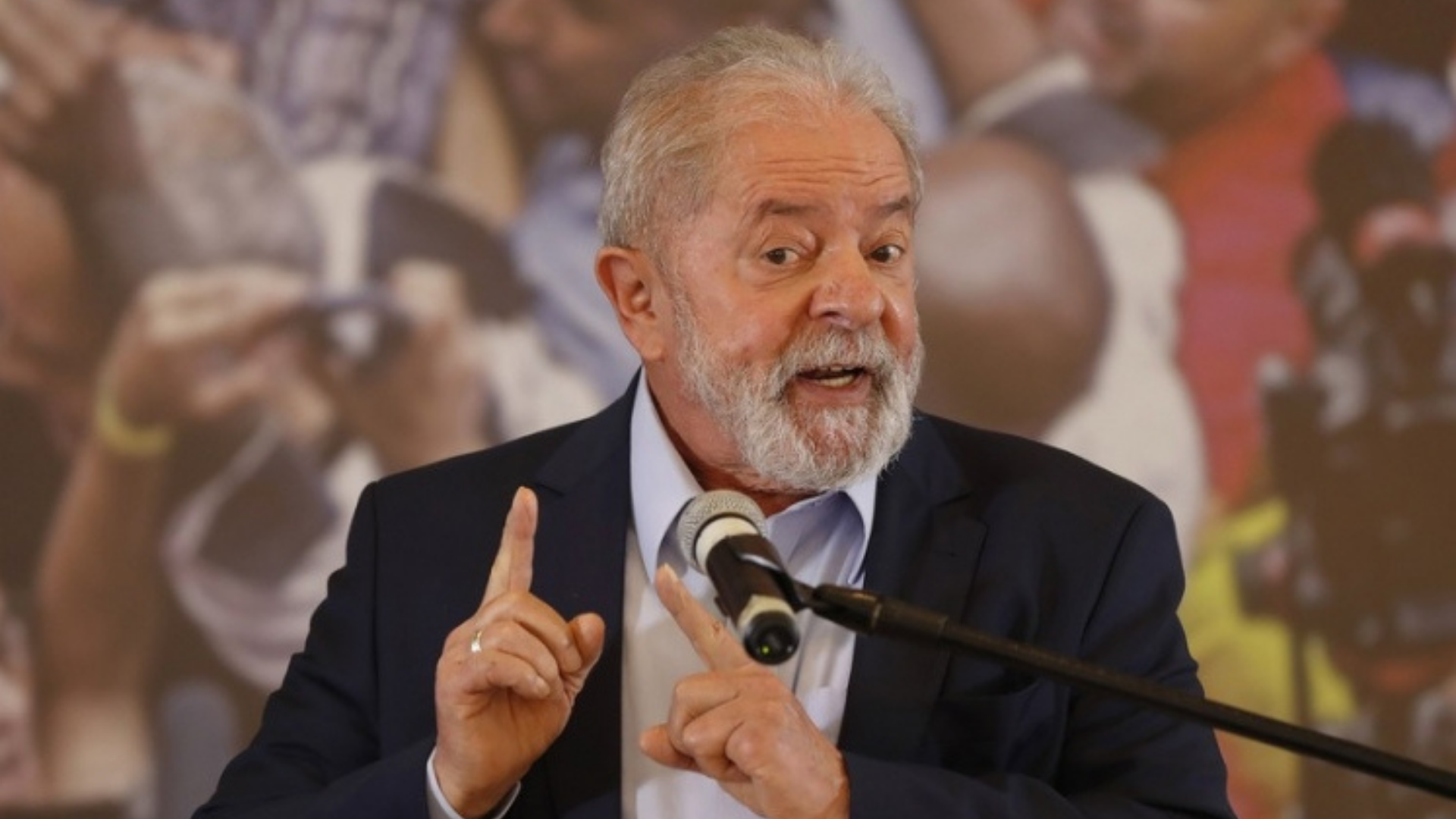 Ex-governador dá invertida em empresários ao defender Lula. Foto do ex-presidente com uma expressão de alerta e apontando os dois dedos indicadores para cima.