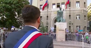 Gabriel Boric saúda estátua de Allende. ele aparece de costas para a câmera e em frente à estátua de Allende.
